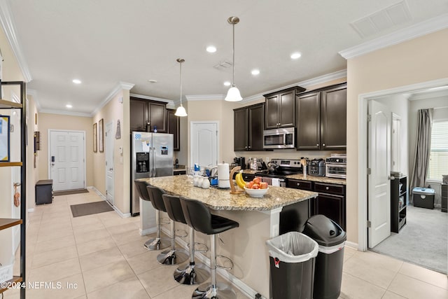 kitchen featuring appliances with stainless steel finishes, ornamental molding, a kitchen island with sink, and decorative light fixtures