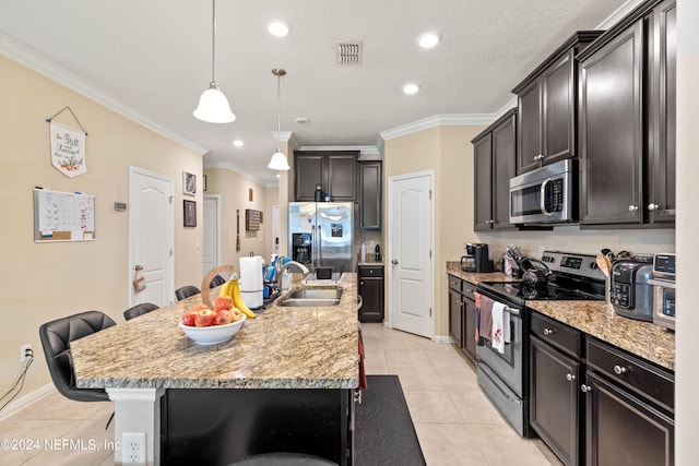 kitchen featuring sink, stainless steel appliances, pendant lighting, a breakfast bar area, and a kitchen island with sink