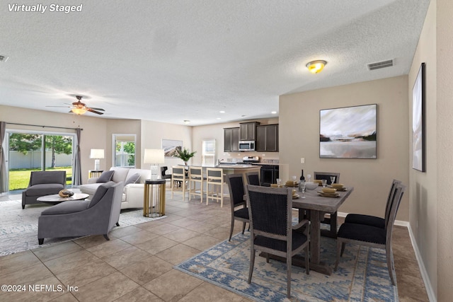 dining room with light tile patterned flooring and a textured ceiling