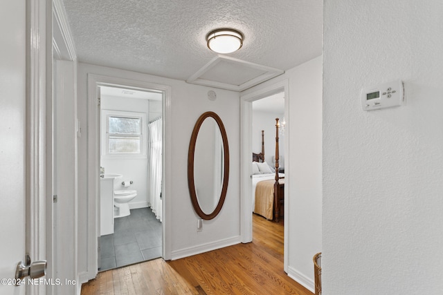 hall featuring a textured ceiling and light hardwood / wood-style floors