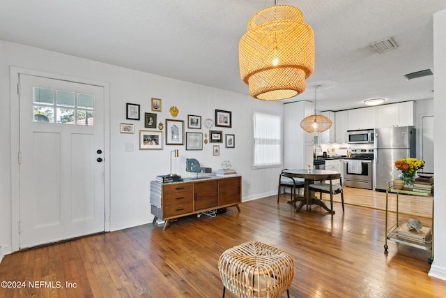 foyer entrance with a textured ceiling, hardwood / wood-style flooring, and a wealth of natural light