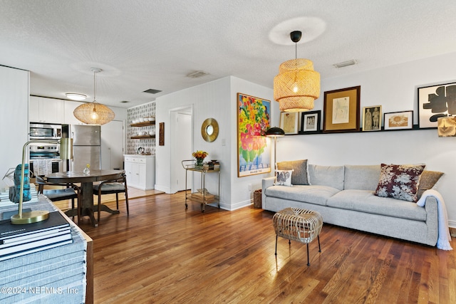 living room featuring a textured ceiling and dark hardwood / wood-style floors