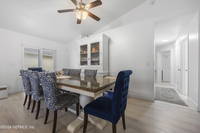 dining room featuring ceiling fan, light hardwood / wood-style flooring, and vaulted ceiling