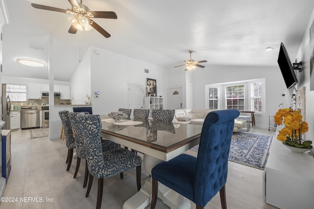 dining room with light hardwood / wood-style flooring, ceiling fan, and lofted ceiling