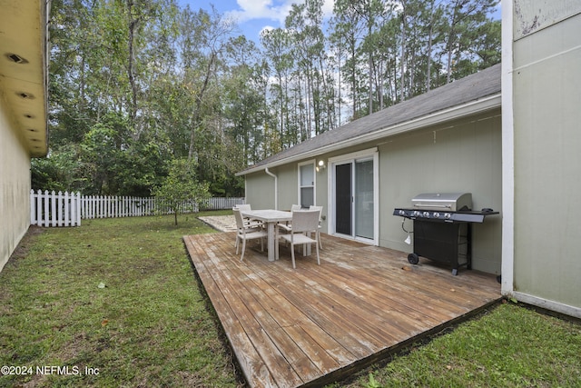 wooden terrace featuring a yard and area for grilling