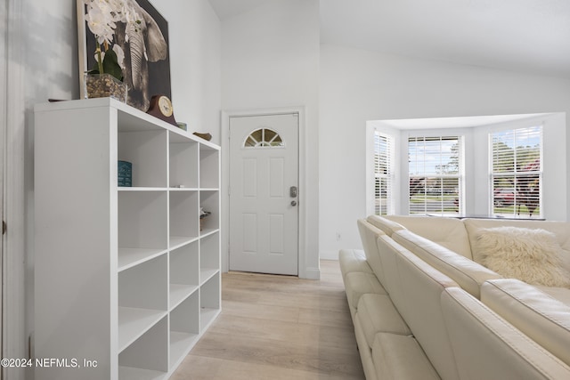 foyer entrance with vaulted ceiling and light hardwood / wood-style flooring