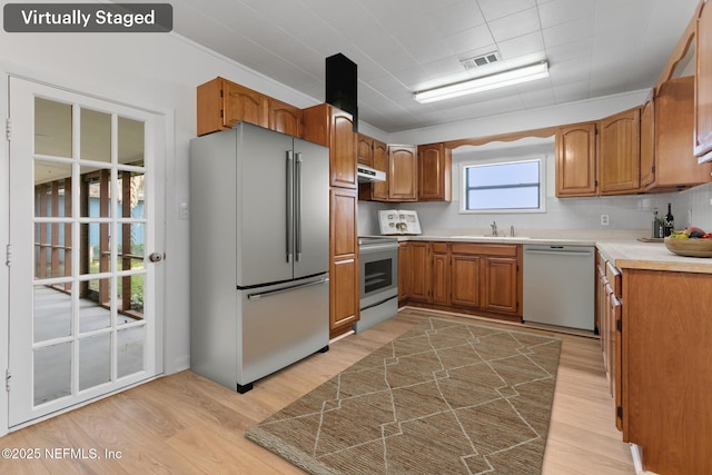 kitchen featuring visible vents, high end fridge, stainless steel electric stove, a sink, and dishwasher