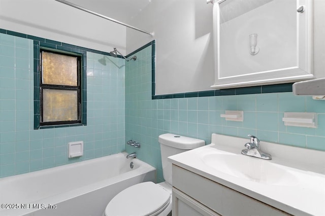 bathroom featuring vanity, toilet, tile walls, and bathtub / shower combination