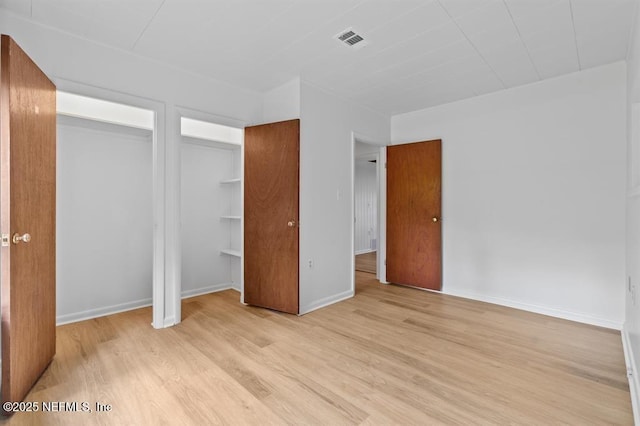 unfurnished bedroom featuring baseboards, visible vents, and light wood-type flooring