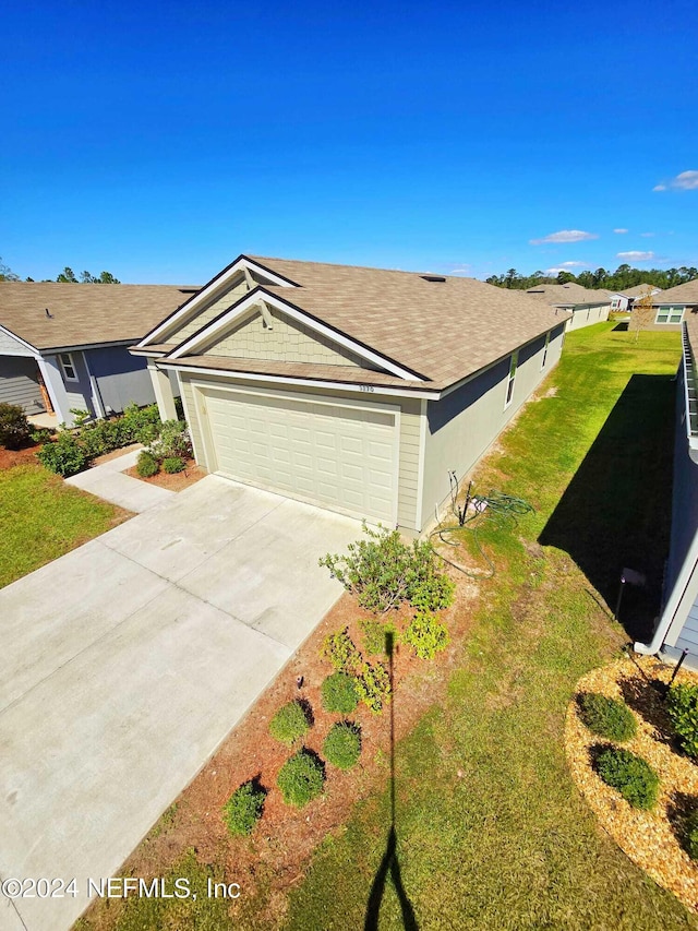 ranch-style house featuring a garage and a front lawn