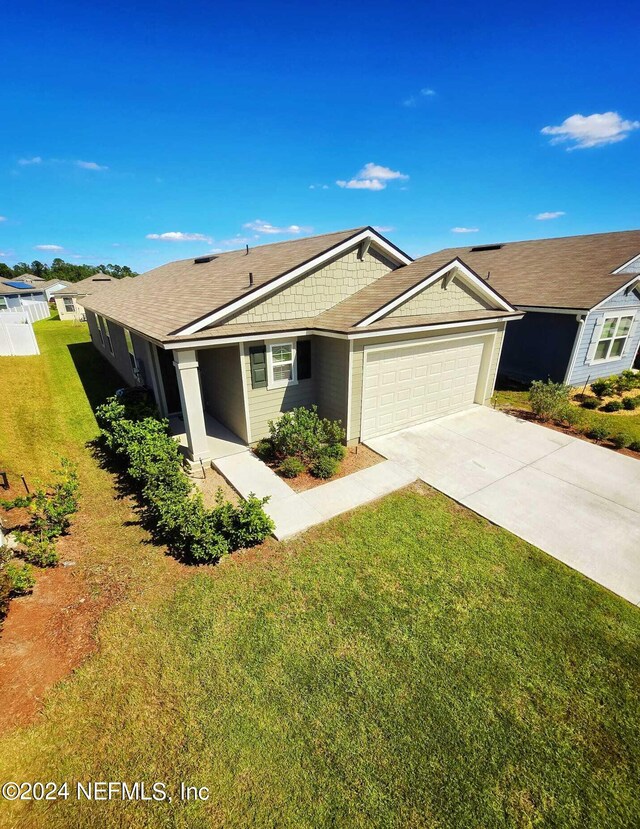 single story home featuring a front lawn and a garage