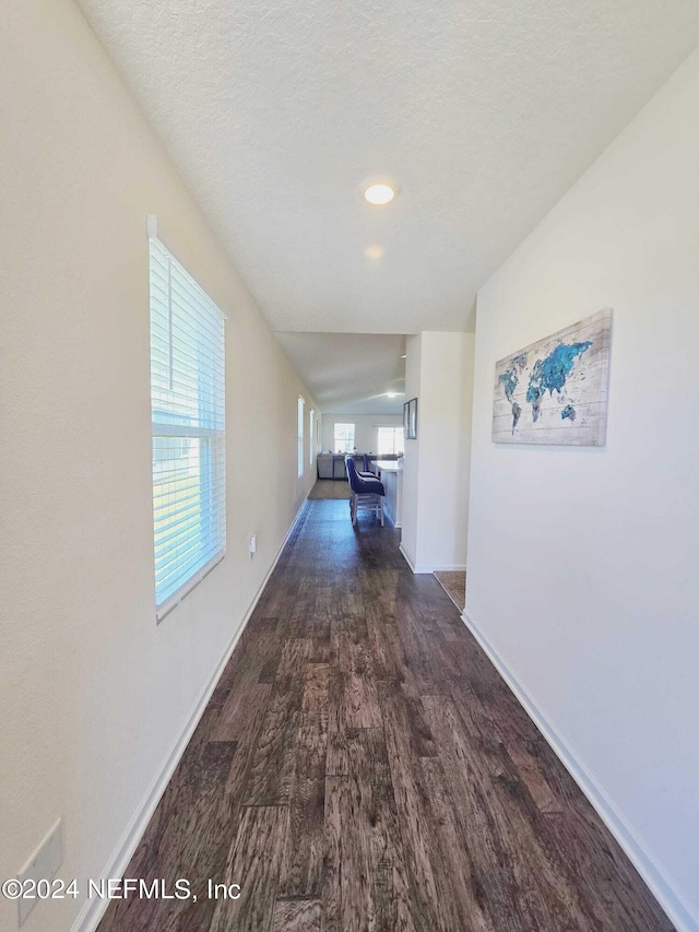 hallway with dark wood-type flooring and a textured ceiling