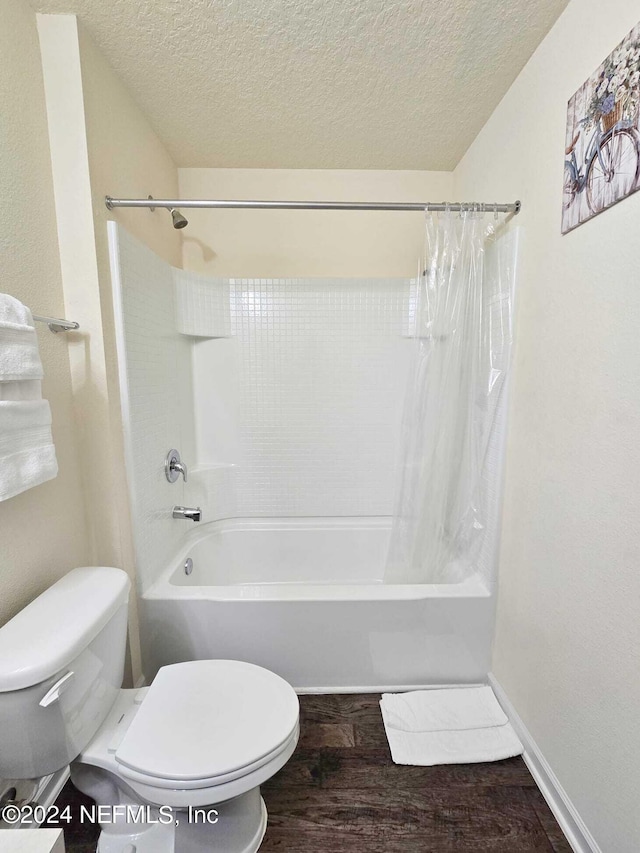 bathroom with a textured ceiling, shower / tub combo with curtain, toilet, and hardwood / wood-style flooring