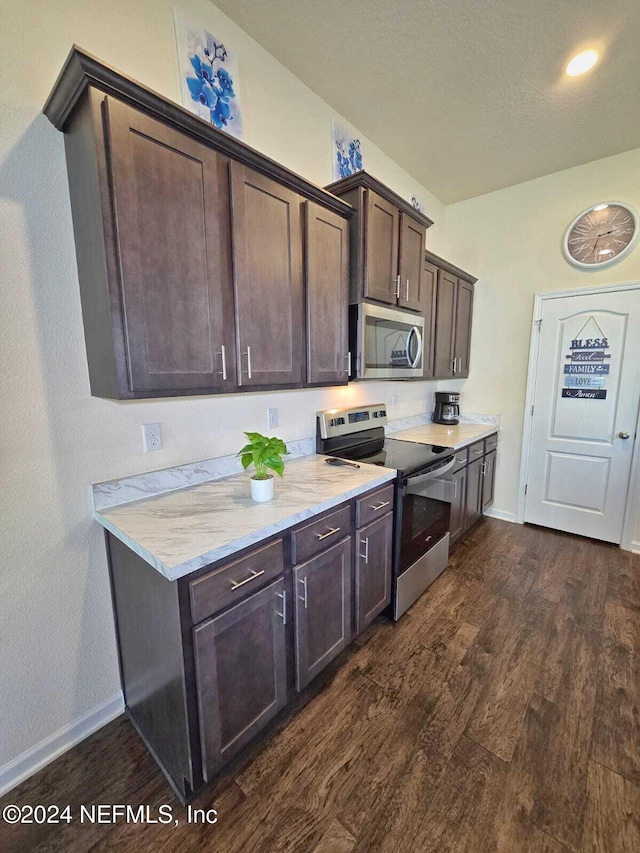 kitchen featuring appliances with stainless steel finishes, light stone countertops, dark brown cabinets, and dark hardwood / wood-style flooring