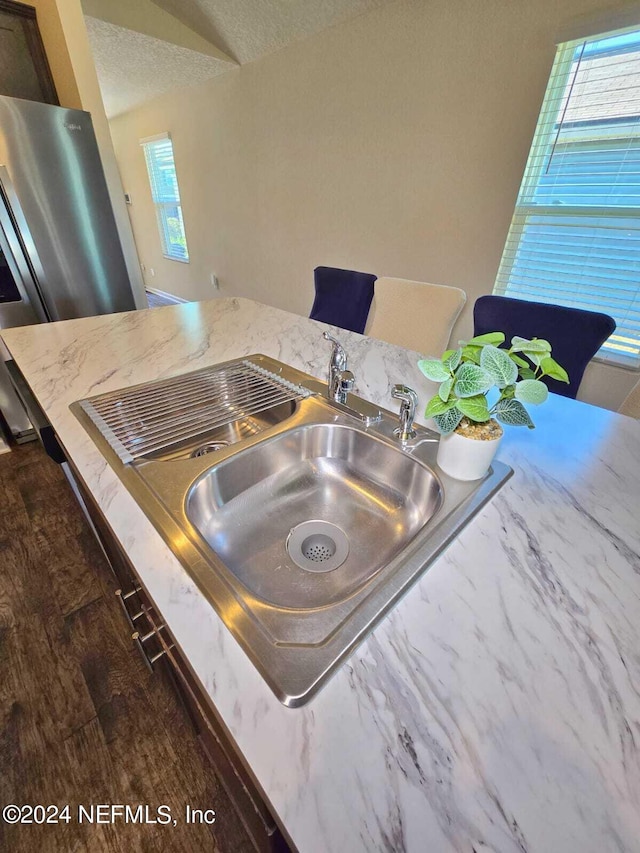 kitchen with sink, light stone countertops, a textured ceiling, and dark hardwood / wood-style flooring