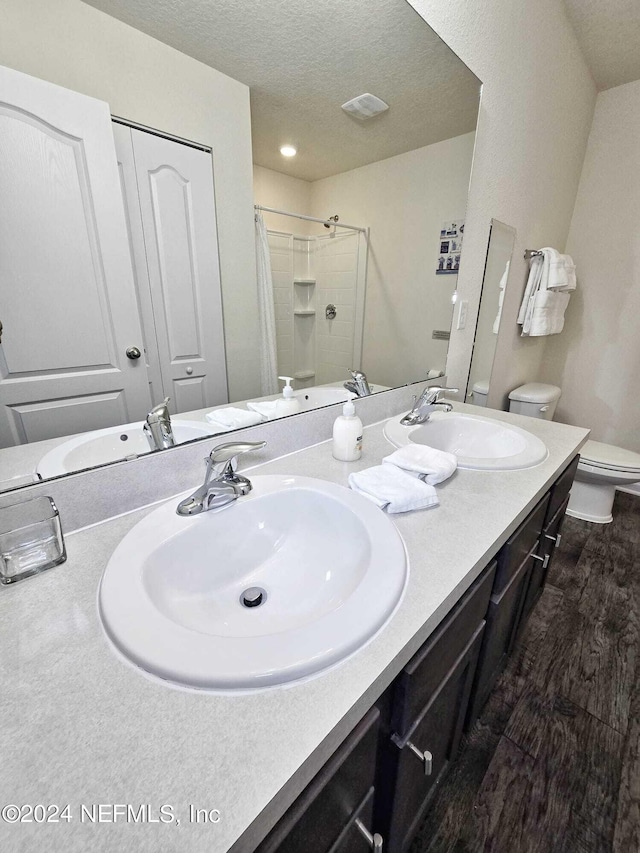 bathroom with vanity, toilet, wood-type flooring, and curtained shower