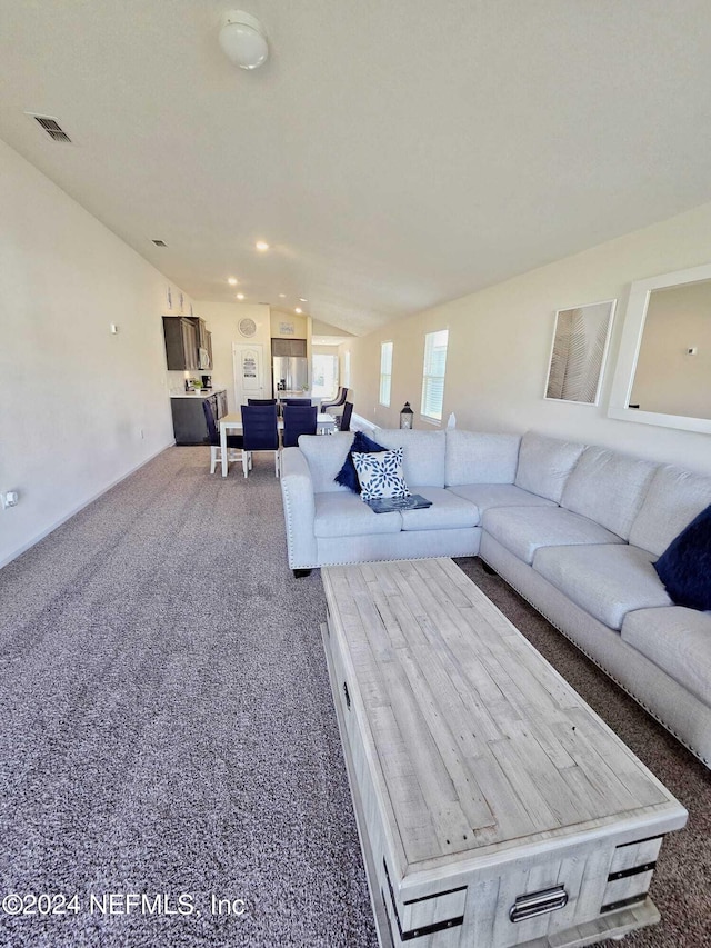 carpeted living room featuring lofted ceiling