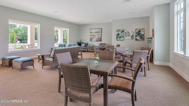 dining area featuring light carpet and a wealth of natural light