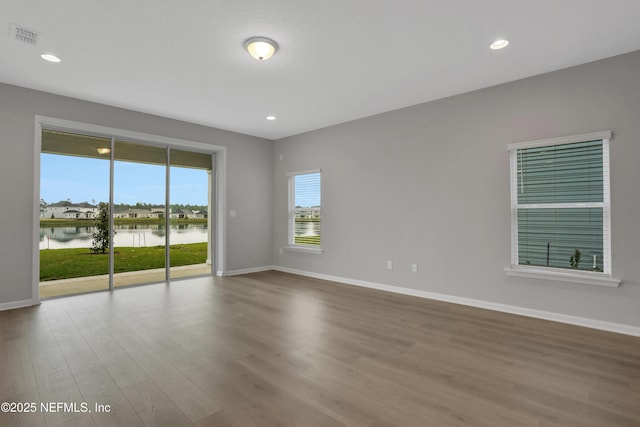 spare room featuring hardwood / wood-style floors and a water view