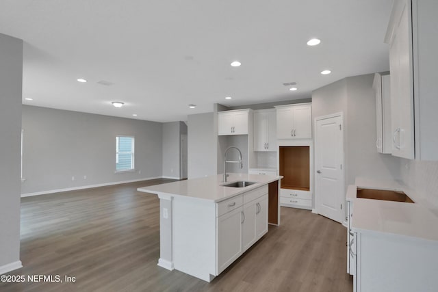 kitchen featuring sink, white cabinetry, an island with sink, and light hardwood / wood-style flooring