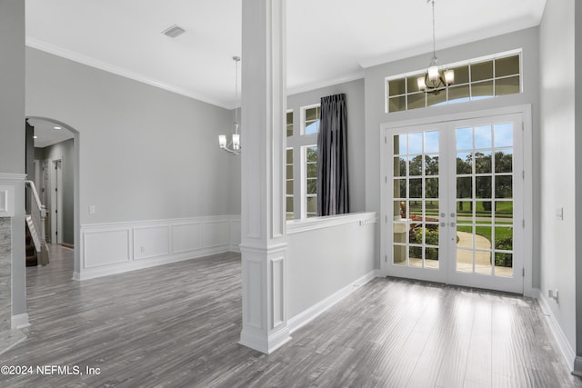 interior space featuring hardwood / wood-style floors, ornamental molding, french doors, and a chandelier