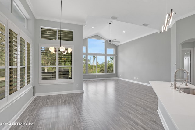 unfurnished living room featuring sink, crown molding, dark hardwood / wood-style flooring, and ceiling fan with notable chandelier