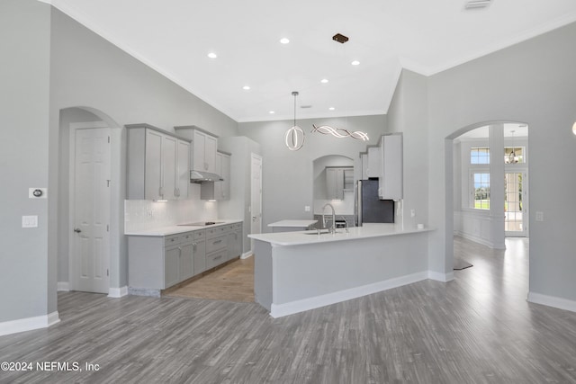 kitchen featuring gray cabinets, kitchen peninsula, stainless steel fridge, and light wood-type flooring