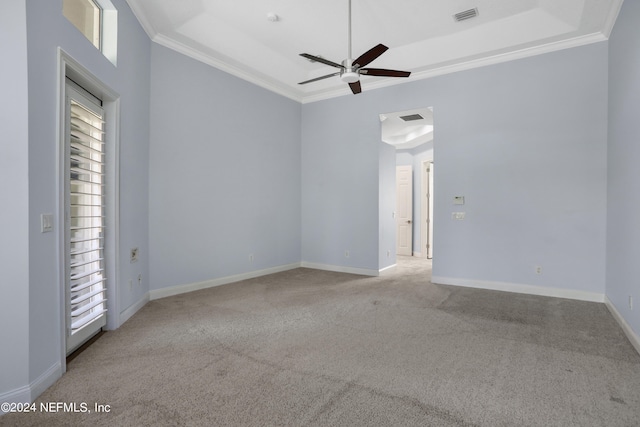 carpeted spare room with crown molding, a raised ceiling, and a wealth of natural light