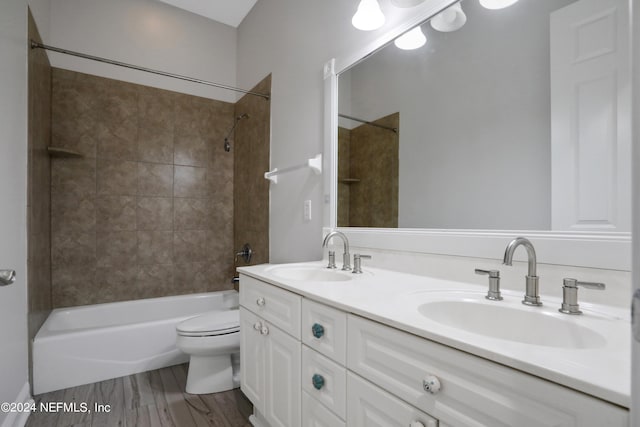 full bathroom with vanity, toilet, hardwood / wood-style flooring, and tiled shower / bath combo