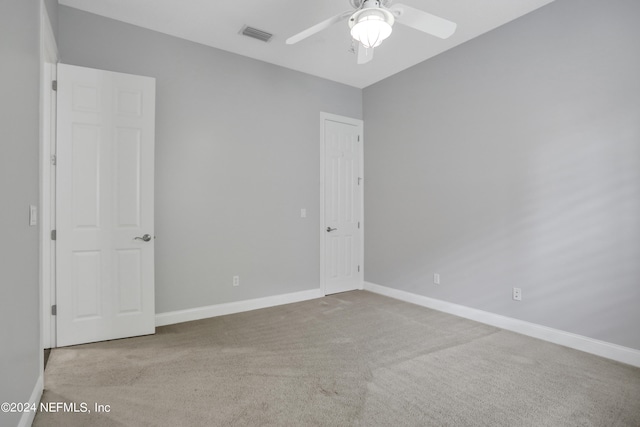 empty room with ceiling fan and light colored carpet