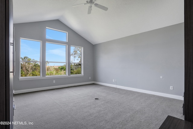 carpeted empty room with ceiling fan and lofted ceiling