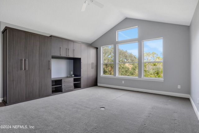 unfurnished living room featuring ceiling fan, vaulted ceiling, and light colored carpet