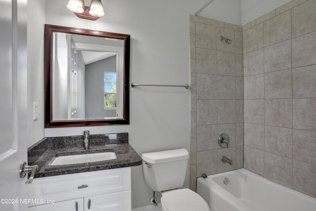 full bathroom featuring vanity, toilet, lofted ceiling, and tiled shower / bath