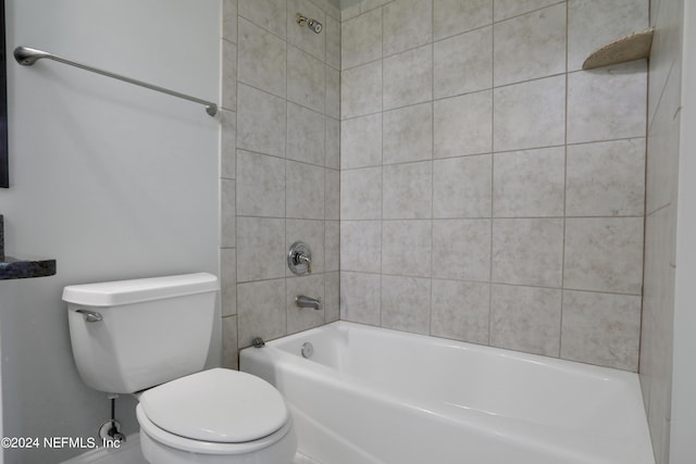 bathroom with toilet and tiled shower / bath