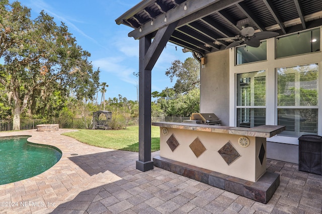 view of patio / terrace featuring area for grilling, ceiling fan, a fenced in pool, and a grill