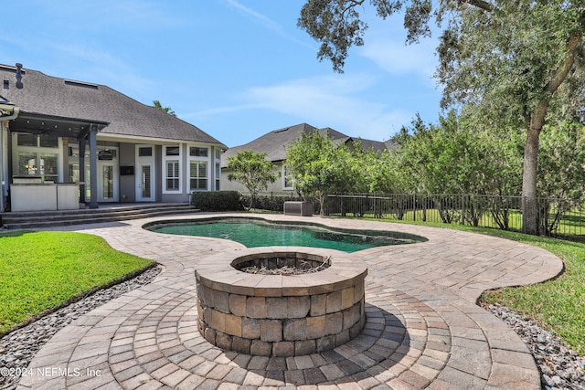 view of swimming pool with an outdoor fire pit and a patio area