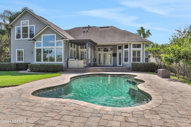 back of house with french doors, a patio, a fenced in pool, and ceiling fan