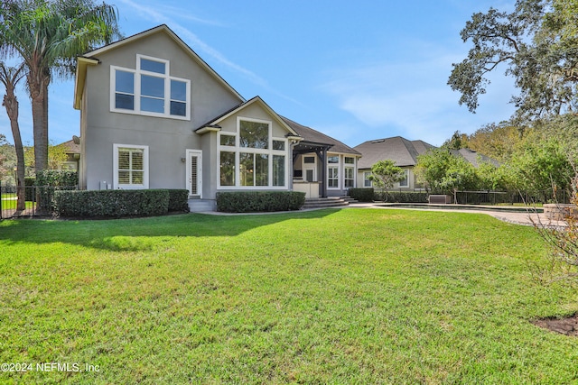 rear view of property with a lawn