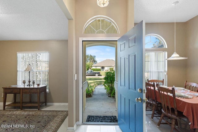 entrance foyer with a textured ceiling, light tile patterned floors, and plenty of natural light