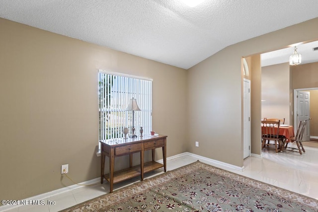 spare room with vaulted ceiling and a textured ceiling