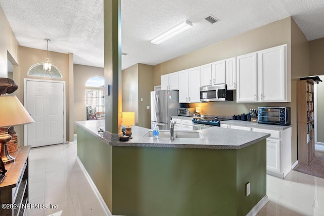 kitchen with sink, appliances with stainless steel finishes, a textured ceiling, and white cabinets