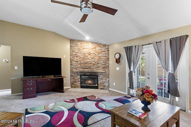 carpeted living room featuring ceiling fan, a textured ceiling, lofted ceiling, and a fireplace