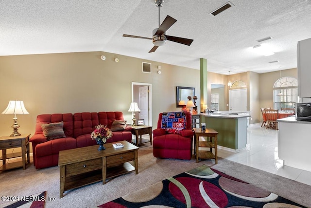 living room with ceiling fan, a textured ceiling, vaulted ceiling, and light tile patterned floors