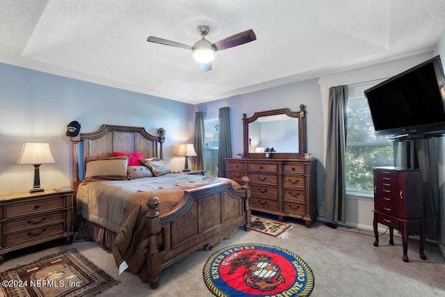 carpeted bedroom with ceiling fan, a textured ceiling, and multiple windows