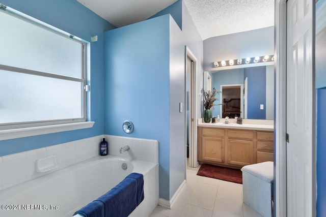 bathroom with a bathing tub, a textured ceiling, vanity, and tile patterned floors