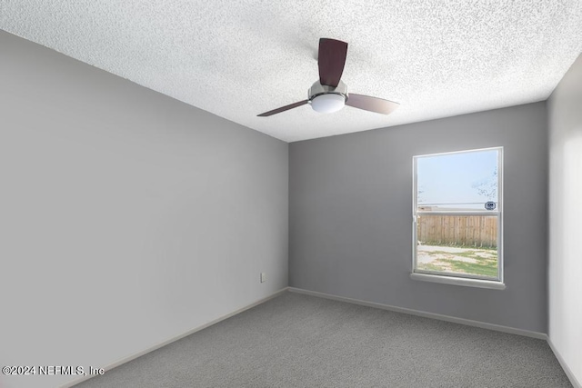 empty room featuring ceiling fan, carpet flooring, and a textured ceiling