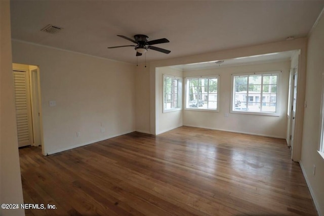 empty room featuring ornamental molding, dark hardwood / wood-style floors, and ceiling fan