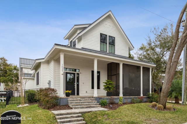 view of front of house featuring a sunroom and a front yard