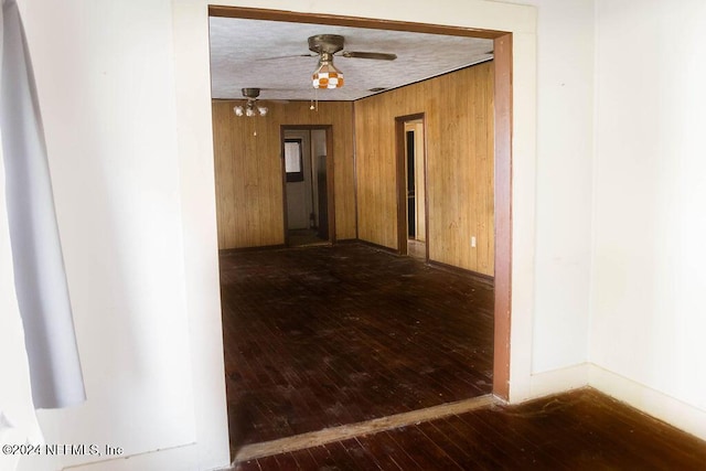 762 N Walnut St, Starke, FL 32091 - unfurnished room featuring hardwood / wood-style floors, wooden walls, a ceiling fan, and baseboards