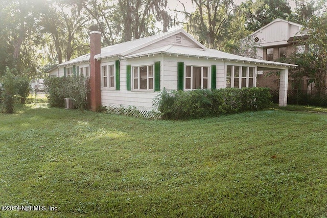 762 N Walnut St, Starke, FL 32091 - view of home's exterior featuring a chimney, metal roof, and central air condition unit